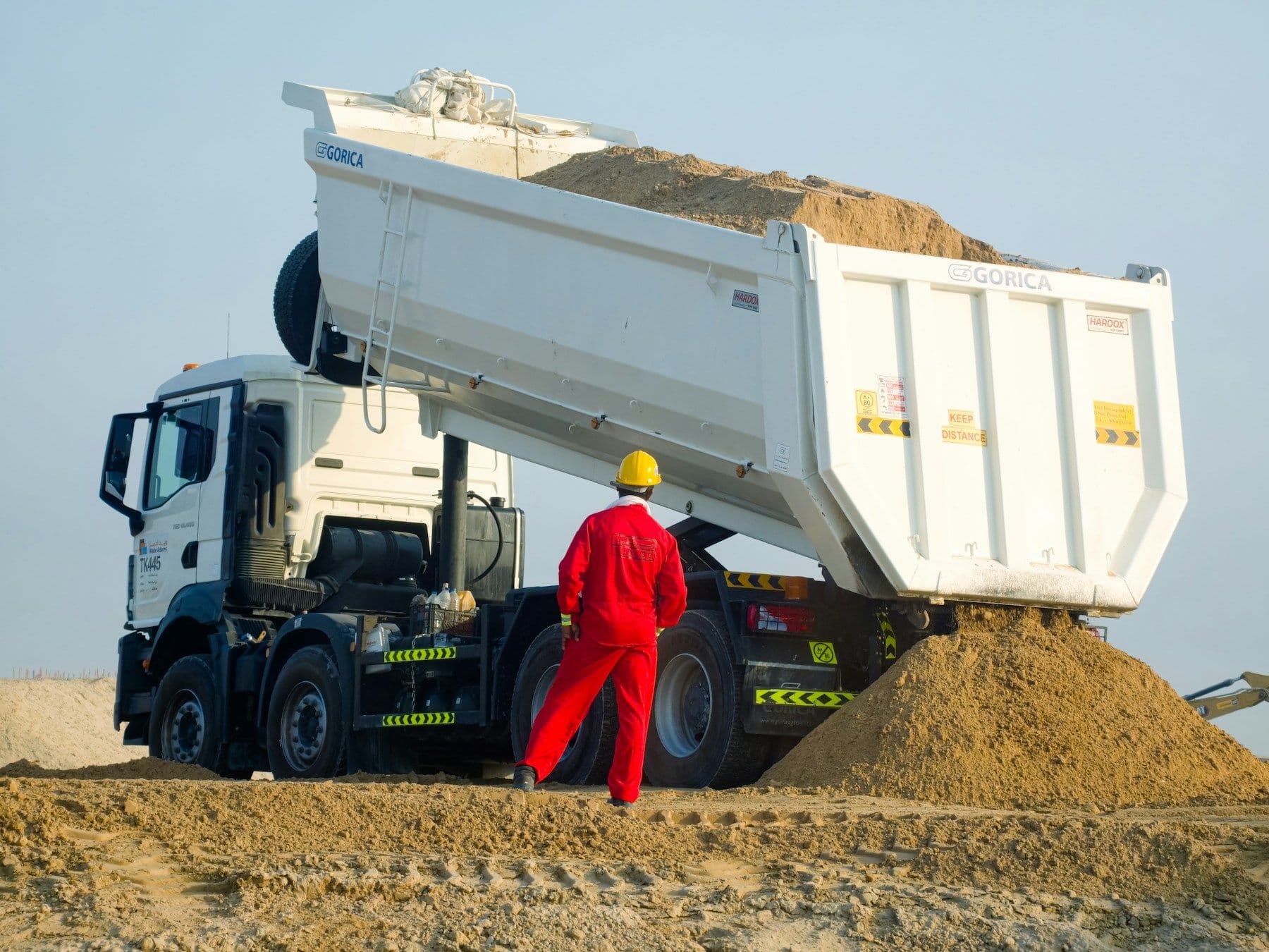 Camion benne déchargeant du sable